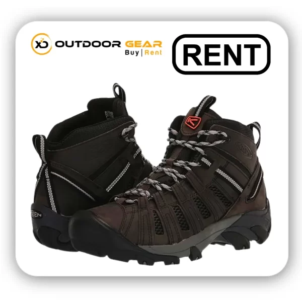 Hikers trekking through a scenic mountain landscape wearing rented hiking boots from Outdoor Gear.